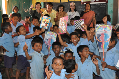 Excited children with the donated sports items and game sets