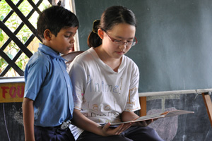 Robyn reading an English passage with a tribal child.