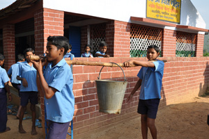 Boys carring water for cleaning and watering