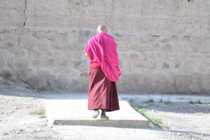 Monk strolling the monastery parameter in prayer.