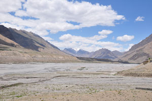 The Spiti River flows through a wide and flat river bed. 