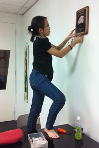 Robyn doing handyman work in Alvin's office